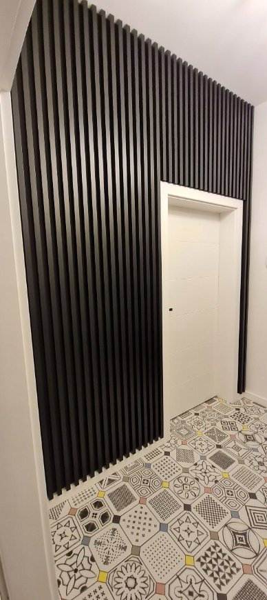 Black Premium 3D wall slats installed floor to ceiling in hallway — real installation
