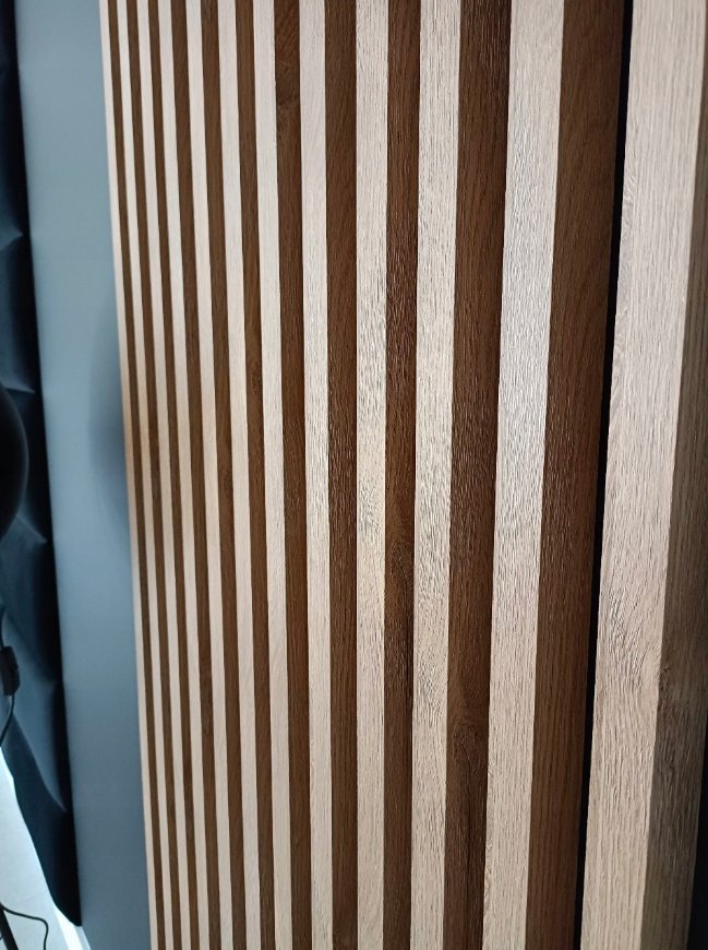 Natural oak Premium 3D wall slats close-up showing grain and depth — real installation