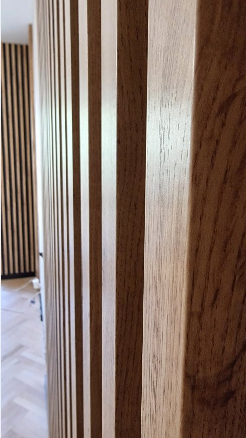 Walnut Premium 3D wall slats wrapping corner — showing 40mm profile depth on real installation